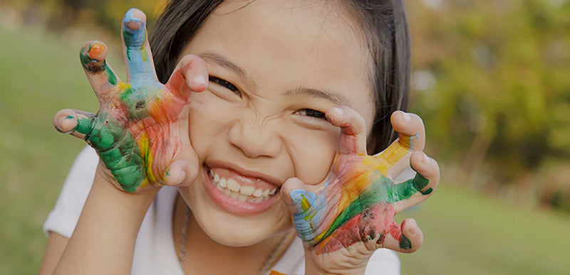 little girl with paint on her hands