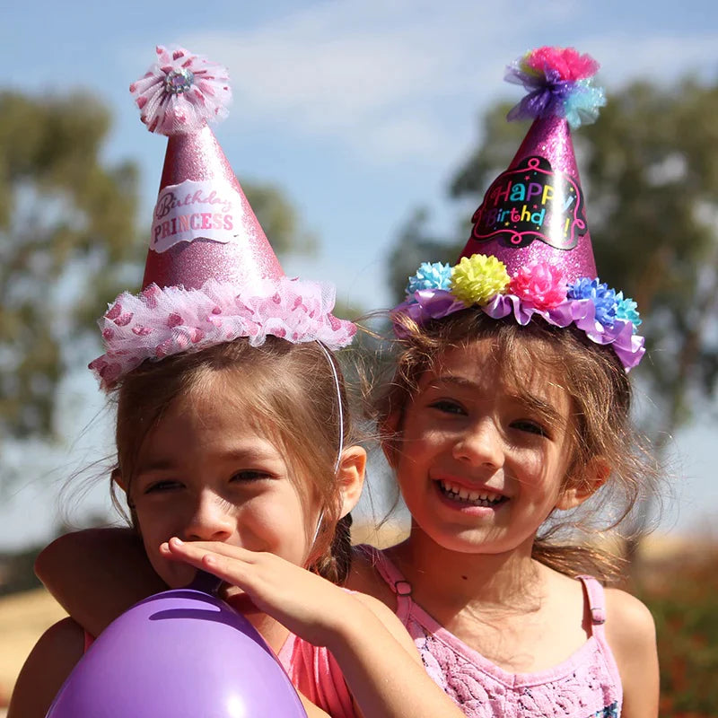2 girls with birthday party hats on